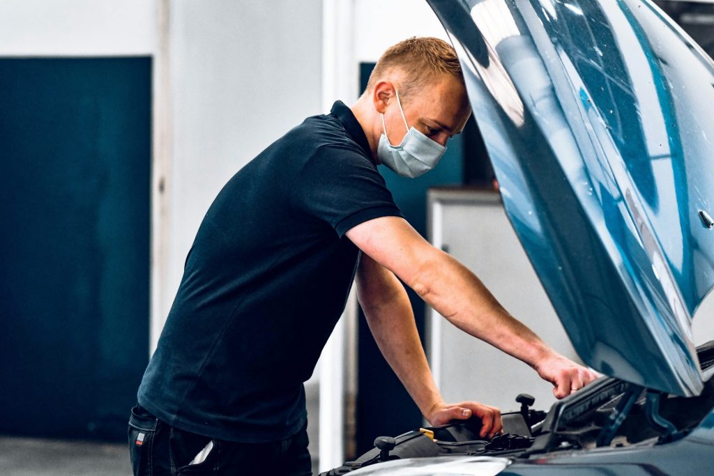Mann in schwarzem T-Shirt hält schwarz-graues Motorrad
